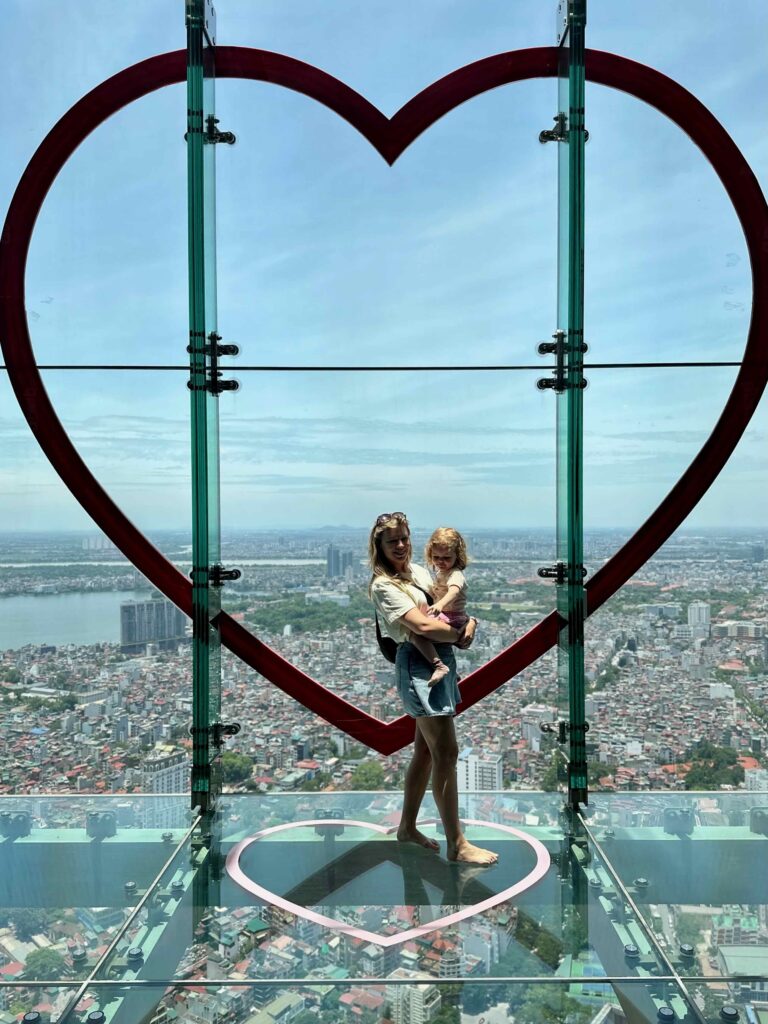 Mama en dochter op het glazen uitzichtplatform in het Sky Lotte Observation Deck in Hanoi, Vietnam