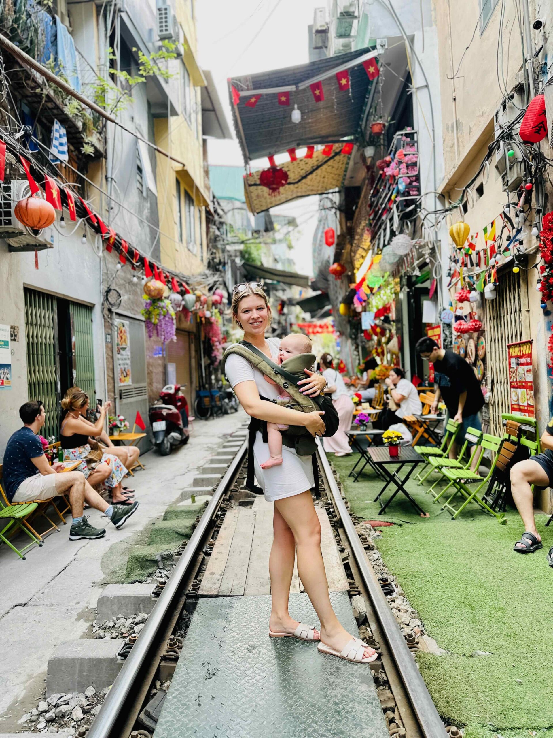 Train street met baby in draagzak, Hanoi - Vietnam